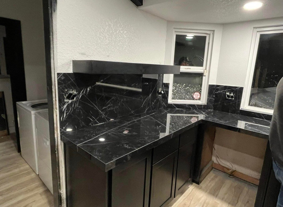 Black marble-look kitchen countertop partway through installation