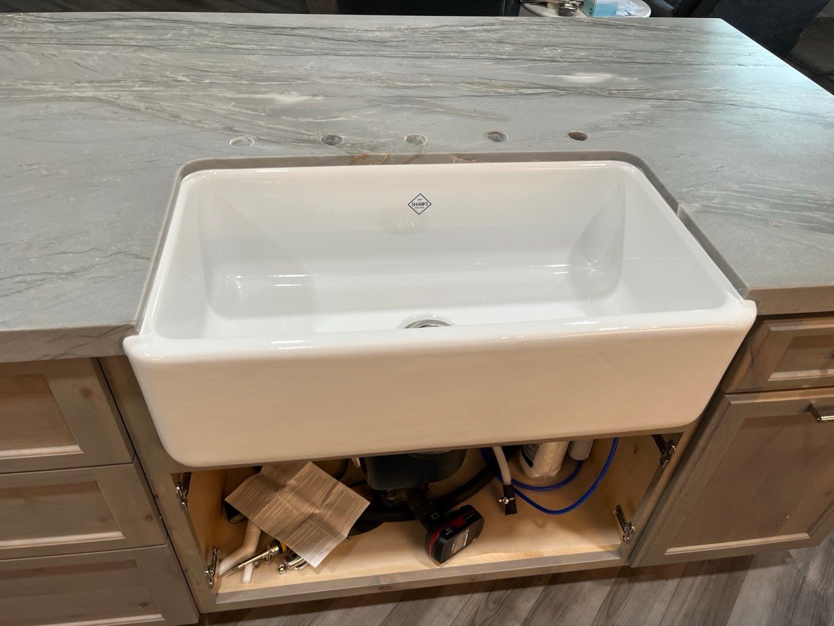 Farmhouse sink set into a white quartz countertop