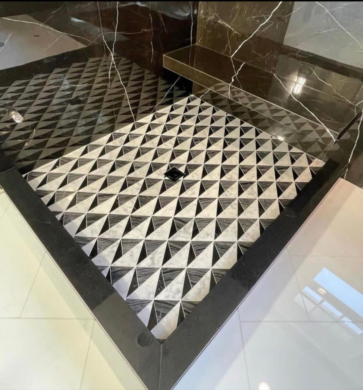 Geometric black, white, and gray marble mosaic shower pan