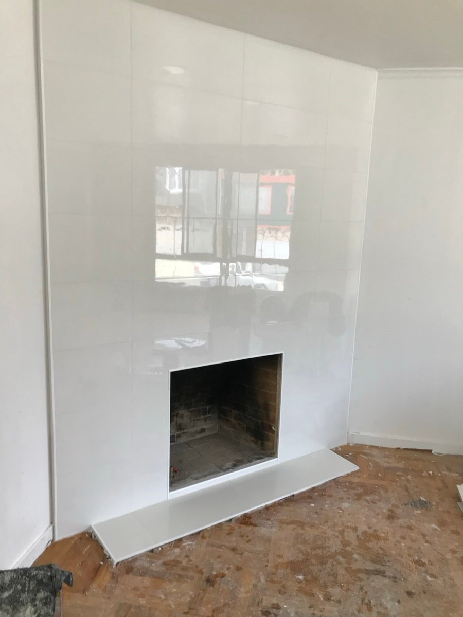 Fireplace surround with white glossy large-format tile